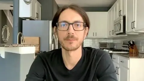 Joshua Aaron, founder of the ICEBlock app, speaking looking directly into a camera when speaking to BBC Verify via Zoom