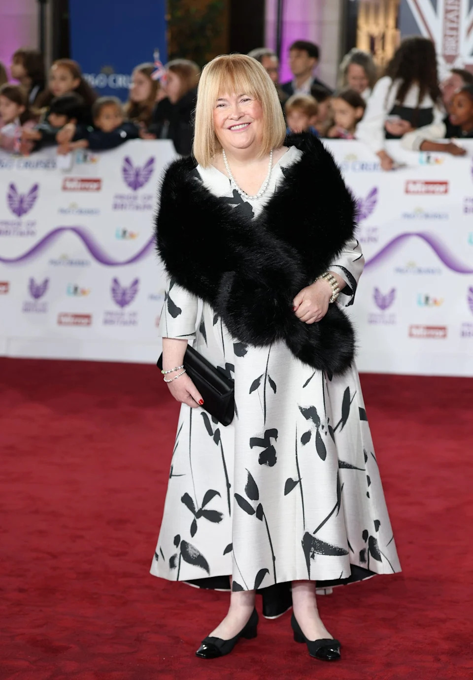 Susan Boyle in a black and white floral dress on the red carpet