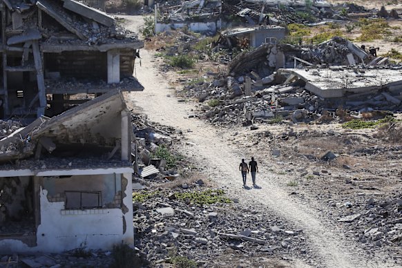 Palestinians walk through the al-Zahra area in central Gaza Strip on Tuesday, as displaced residents return to their homes.
