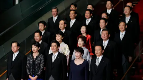 Bloomberg via Getty Images Shinzo Abe poses for a group photograph with members of his new cabinet at the prime minister's official residence in Tokyo