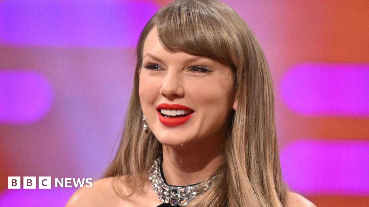A close-up of Taylor Swift. She is on a TV chat show and is smiling.