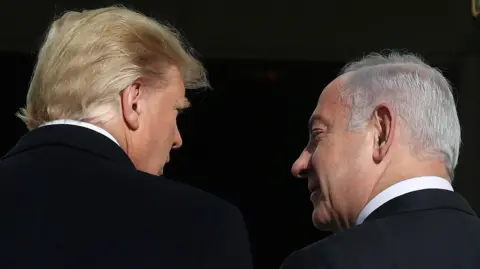 Getty Images Trump is on the left with his back to the camera, looking right towards Netanyahu who is also with his back to the lens, looking left towards Trump. Both men have dark suits and white shirts