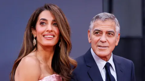 EPA/Shutterstock George Clooney on the Jay Kelly red carpet with his wife Amal Clooney