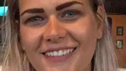 PA Media A young blond woman with blue eyes looks at the camera. It is a very close shot so her face fills the screen.