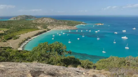 Getty Images Small and large boats in a bay with turquoise waters 