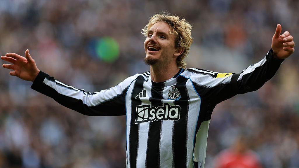 Nick Woltemade smiles and has his arms out in celebration