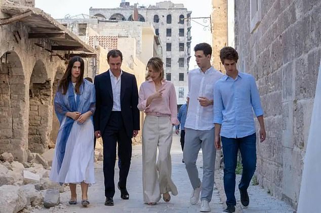 Former Syrian President Bashar al-Assad, his wife Asma (C) and their children Zein, left, Karim, right, and Hafez walk outside the Great Mosque of Aleppo, Syria