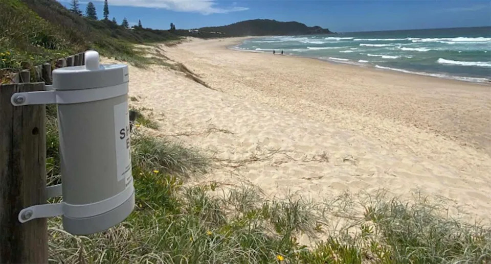 A shark bite kit is mounted to a fence post at a beach in NSW.