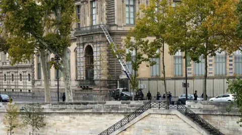 Getty Images French police officers stand next to a furniture elevator used by robbers to enter the Louvre Museum