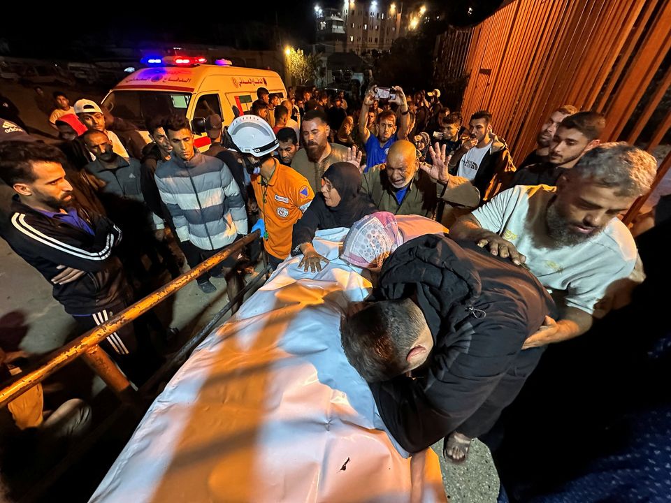 Palestinians carry a man killed in an Israeli strike at Nasser Hospital