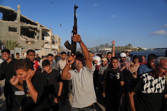 A man shoots in the air during the funeral of Palestinians killed by Israeli fire, in Deir al-Balah, Gaza on Sunday.