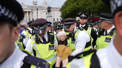 PA Media Police remove a protester taking part in a demonstration organised by Defend our Juries