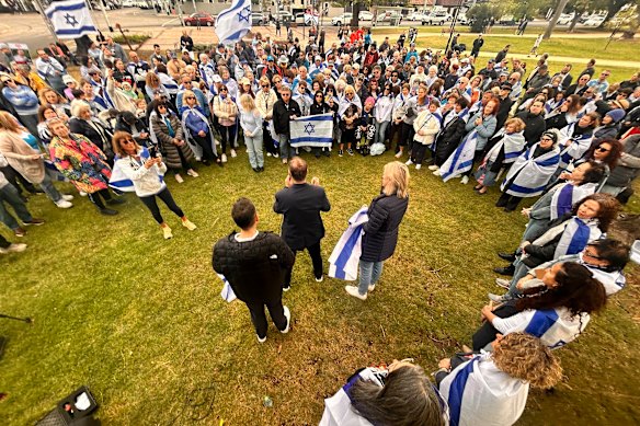 State Liberal MP David Southwick (centre) addresses the crowd while flanked by fellow Liberal MPs James Newbury and Georgie Crozier. They joined about 200 members of the Jewish community who gathered on Sunday morning in Caulfield Park.