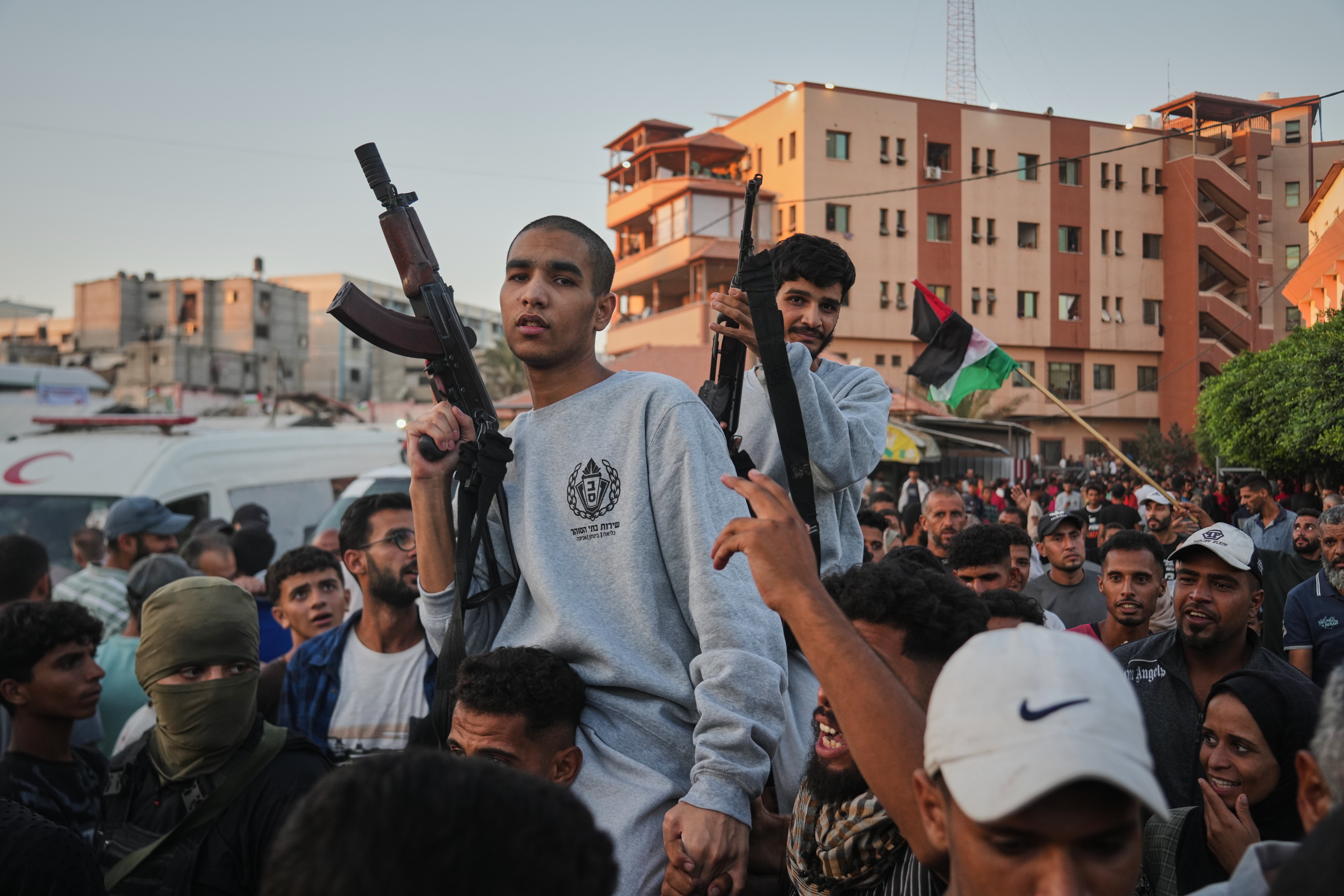 Freed Palestinian prisoners carry rifles as they arrive in the Gaza Strip following their release from Israeli jails, following a ceasefire agreement between Hamas and Israel, outside Nasser Hospital in Khan Younis, southern Gaza Strip, Monday, Oct. 13, 2025. (AP Photo/Abdel Kareem Hana)