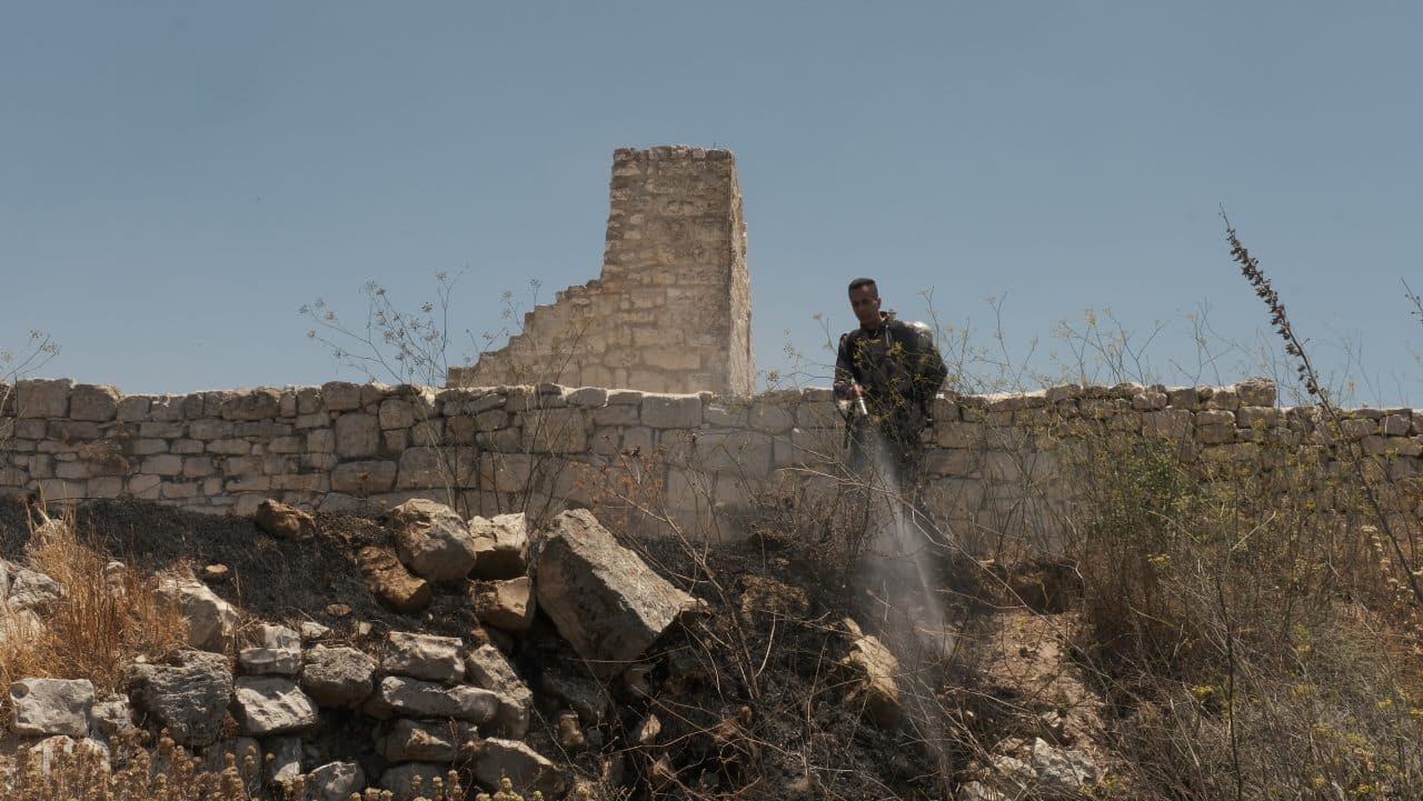Villagers in Taybeh put out fires started by Israeli settlers outside the al-Khader Church in Taybeh, northeast of Ramallah, July 7, 2025. (Photo: Qassam Muaddi/Mondoweiss)