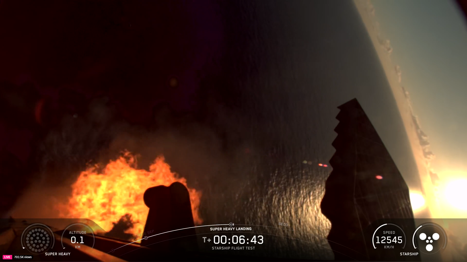 A giant booster fires its engines to land before splashing down in the ocean