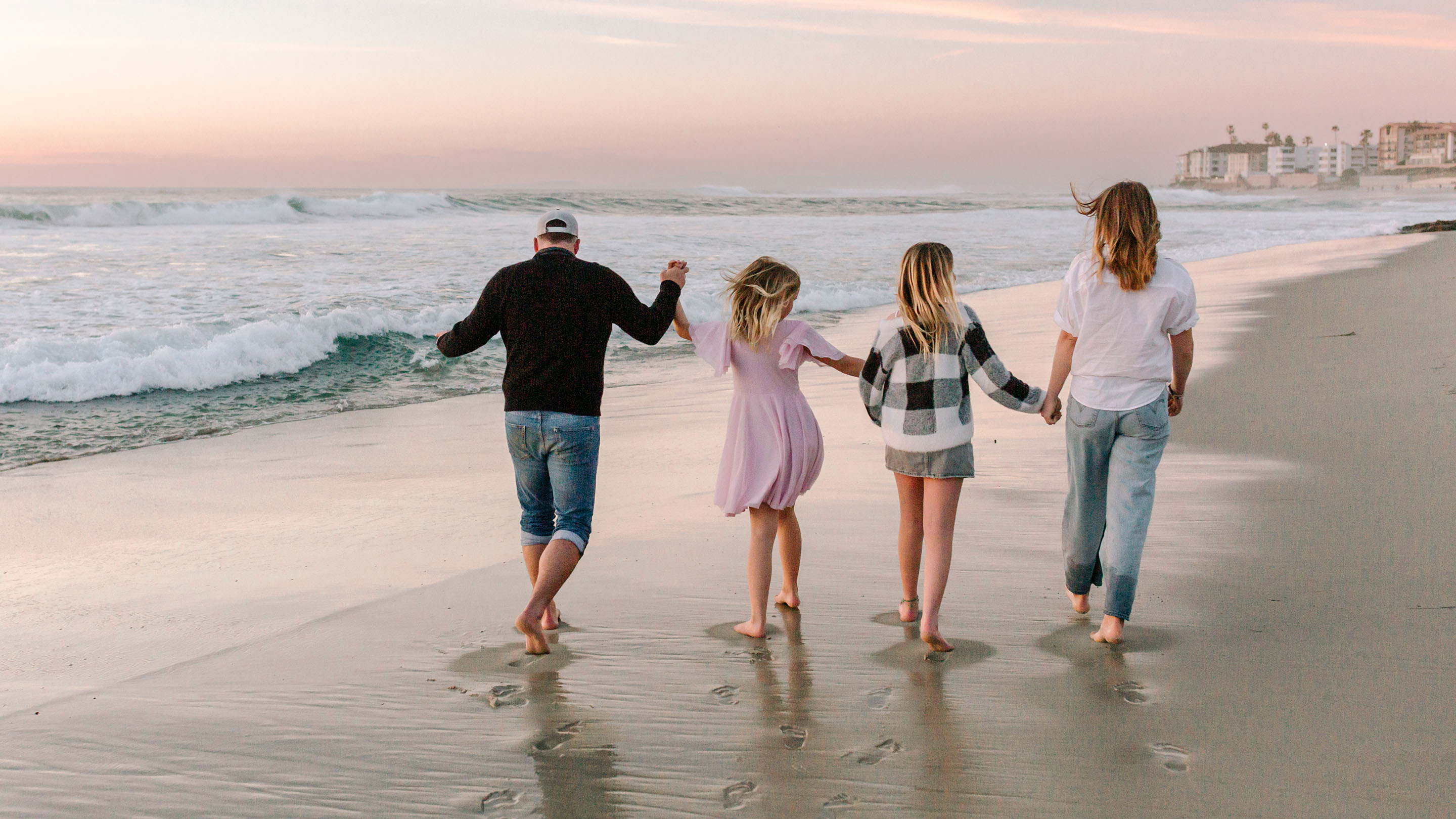 Family with teenagers together on the beach at sunset