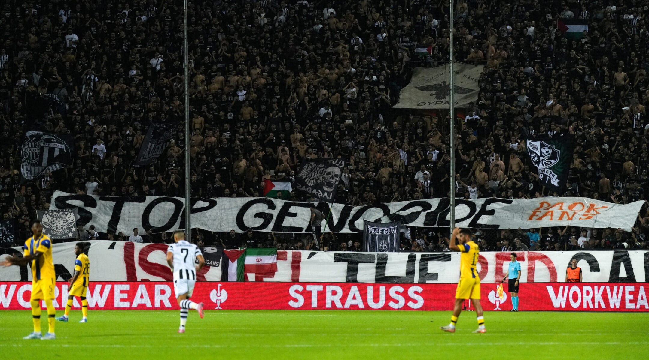 Fans raise a banner that reads "Stop Genocide — Show Israel the Red Card" during a September football match between PAOK and Maccabi Tel Aviv in Greece.