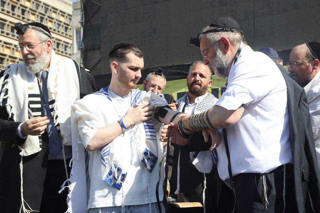שורד השבי בר קופרשטיין הגיע לכיכר החטופים לאירוע הנחת תפילין