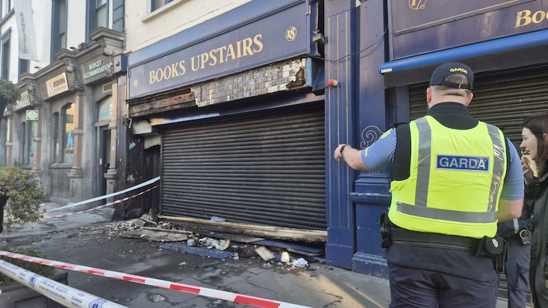 A garda stands outside the fire-damaged Books Upstairs. Photograph: Claire Murphy