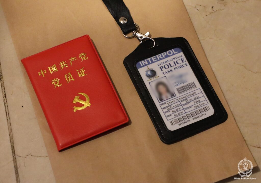 Identification card with a black border and a small red folder with gold writing