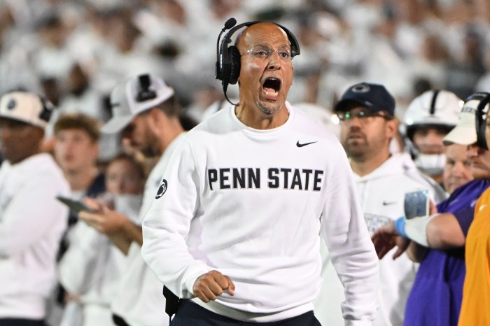 Penn State head coach James Franklin, wearing a white Penn State sweatshirt, looks surprised on the sidelines.