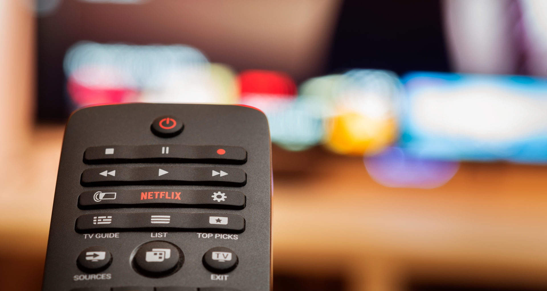 TV Remote with Dedicated Netflix Button in front of Defocused Smart TV Allard Schager / Alamy