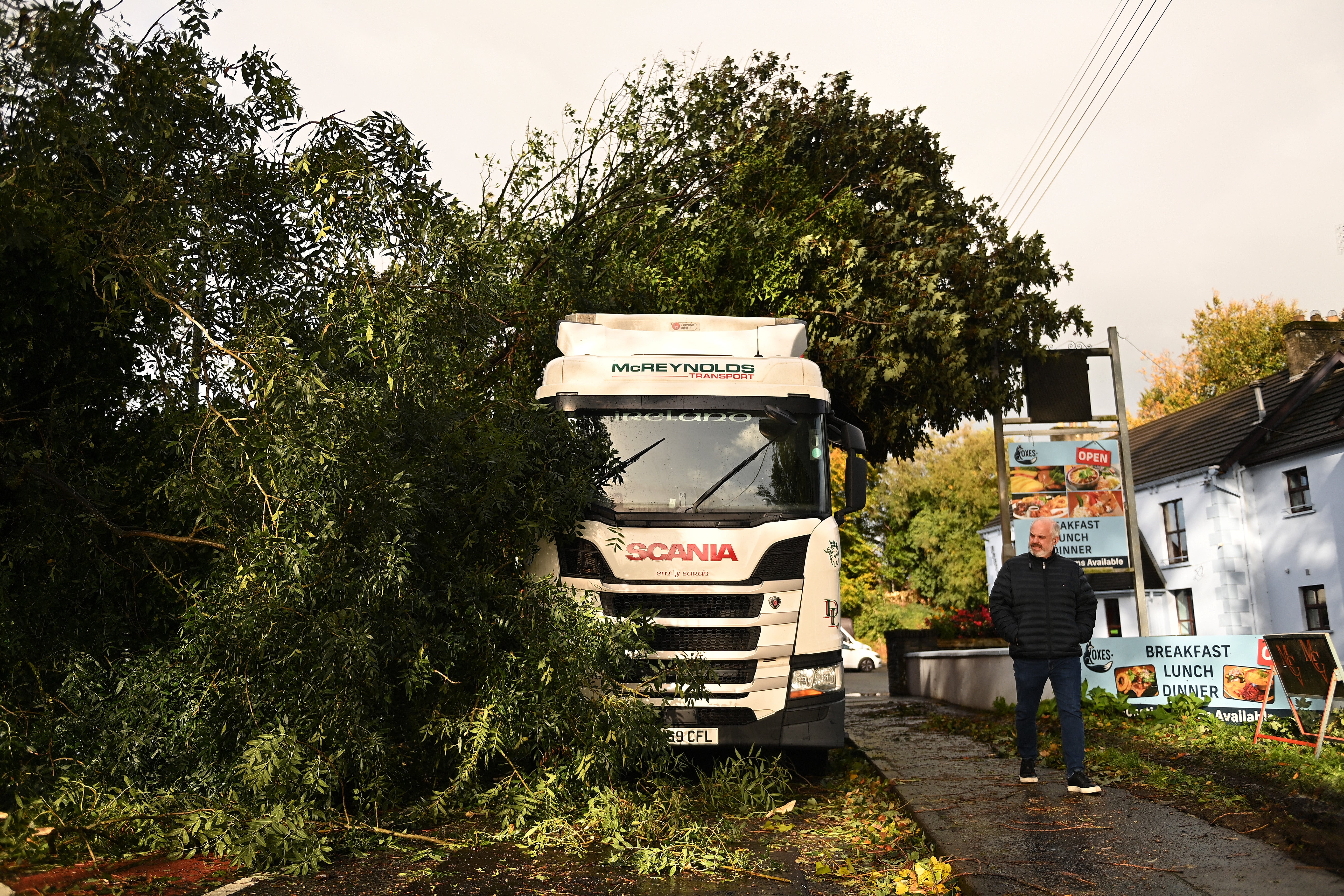A lorry remains stuck after being hit by a falling tree due to high winds caused by Storm Amy in Antrim, Northern Ireland