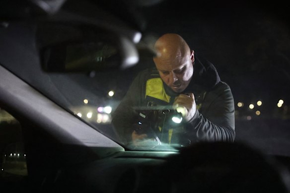 Security guard Grant Burton checks an abandoned car in Manor Lakes during a night patrol.