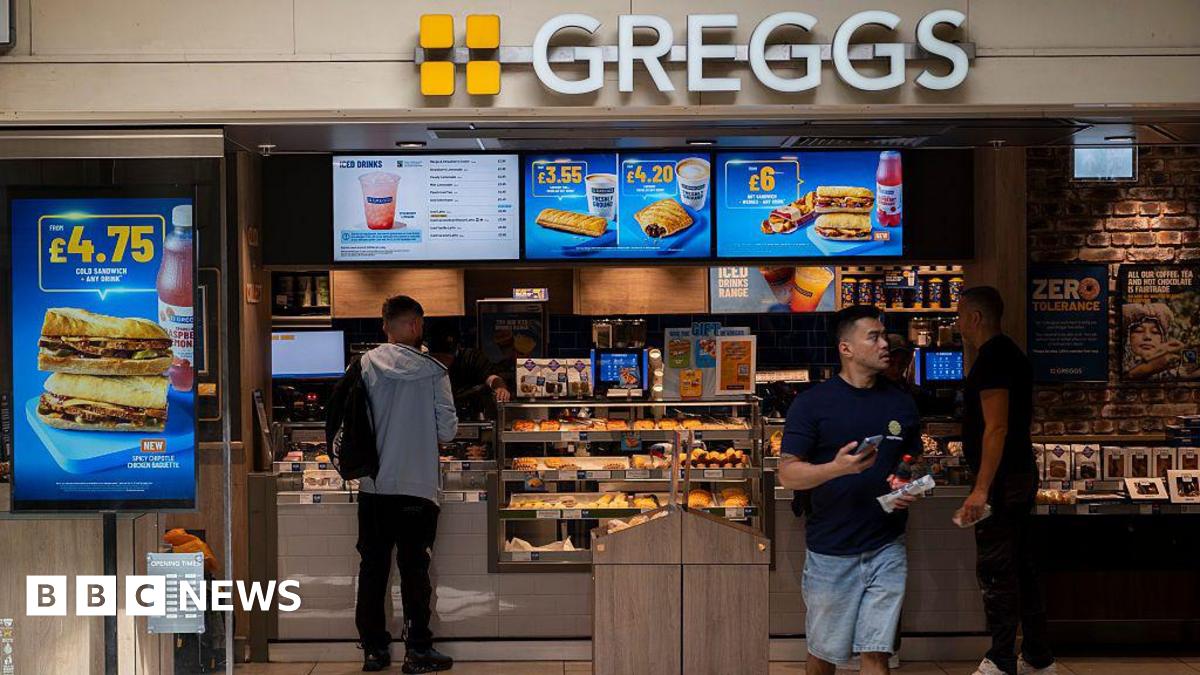 A customer exits a Greggs bakery with a meal deal while another shopper pays at the bakery chain's till