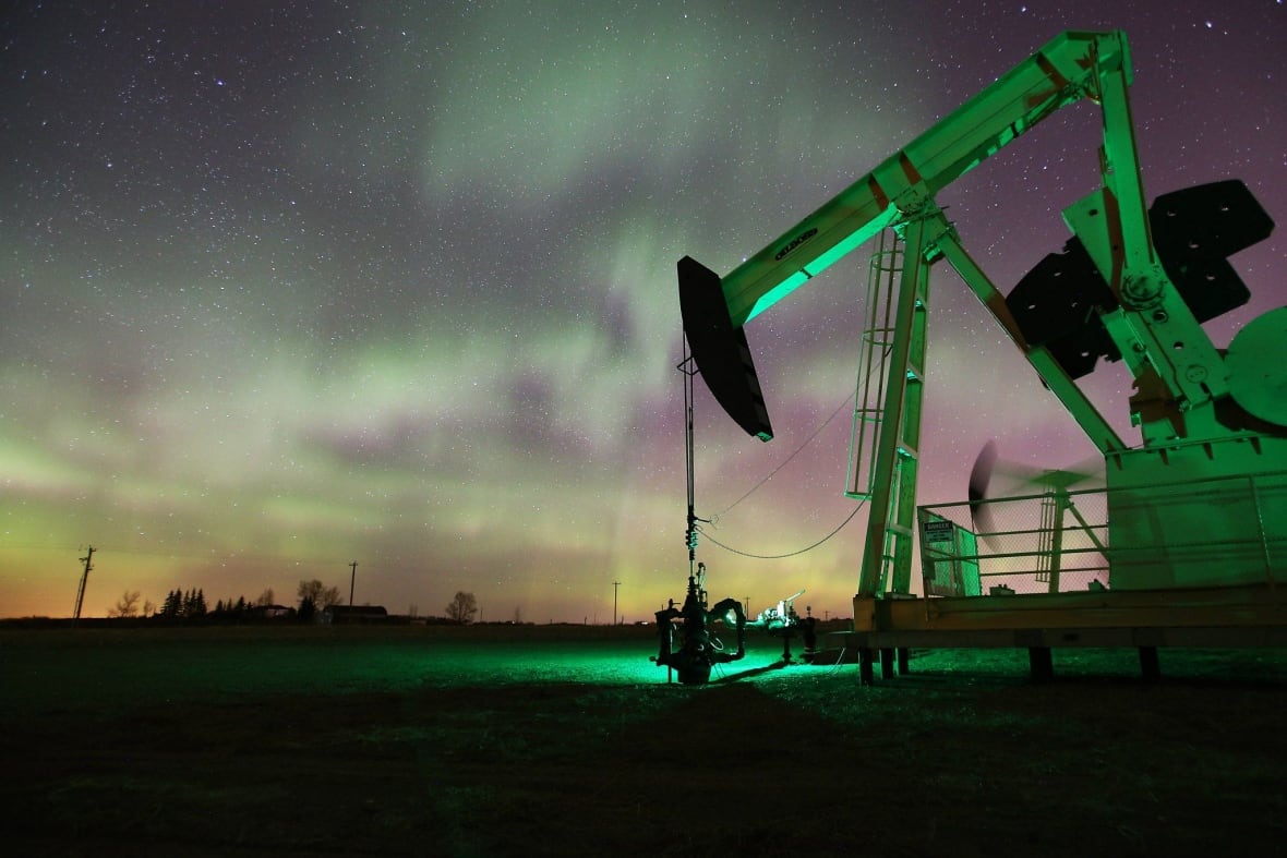 A pumpjack operates beneath the aurora borealis northwest of Calgary.