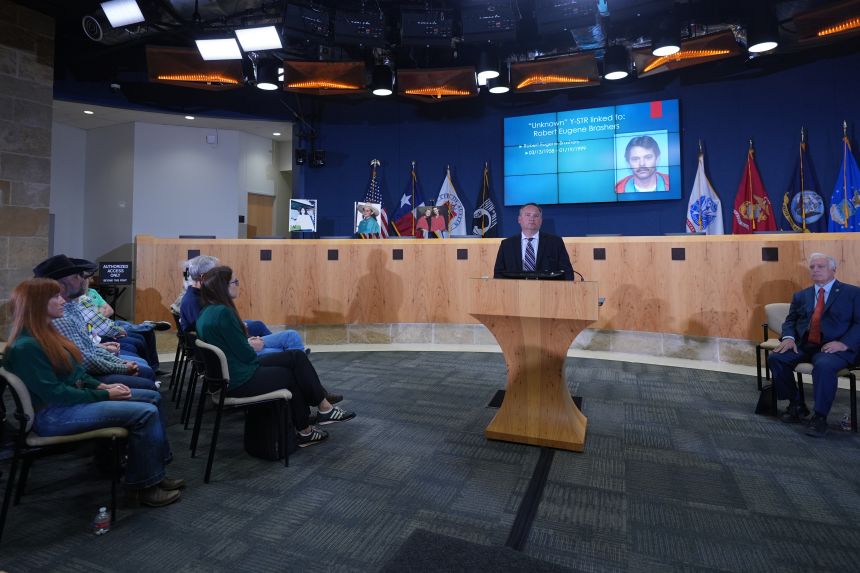 Detective Dan Jackson speaks during a news conference regarding a breakthrough in the 1991 yogurt murders case in Austin. An image of suspected killer Robert Eugene Brashers is displayed on the screen above Jackson.