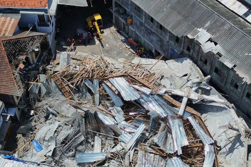 A drone shot shows rescuers searching for victims trapped under the collapsed building.