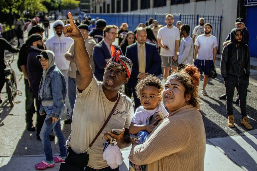 Stunned onlookers gather near a high-rise affordable housing building that partially collapsed.