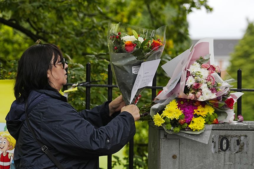 A woman places bunches of flowers and tribute messages at the Heaton Park Hebrew Congregation synagogue in Crumpsall on Friday.