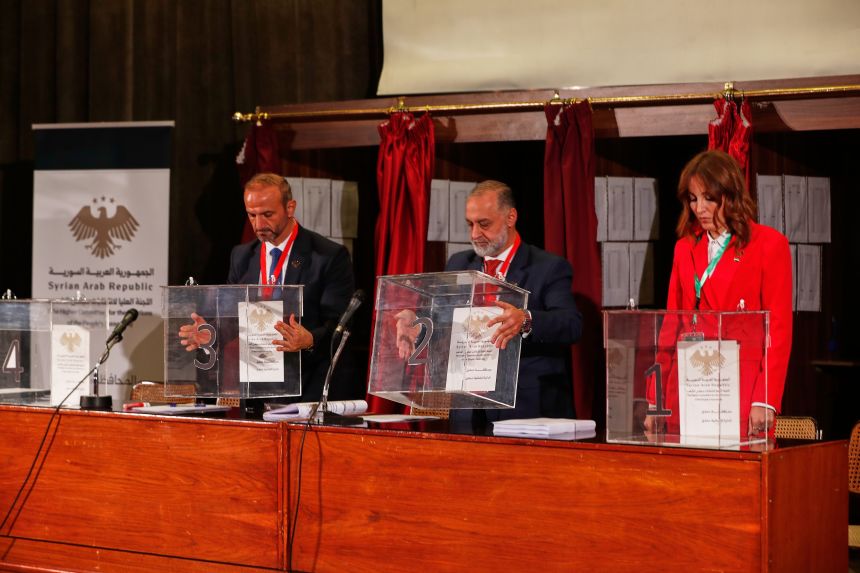 Officials prepare ballot boxes for electoral college members ahead of voting in a parliamentary election at a polling station in Damascus, Syria on October 5, 2025.