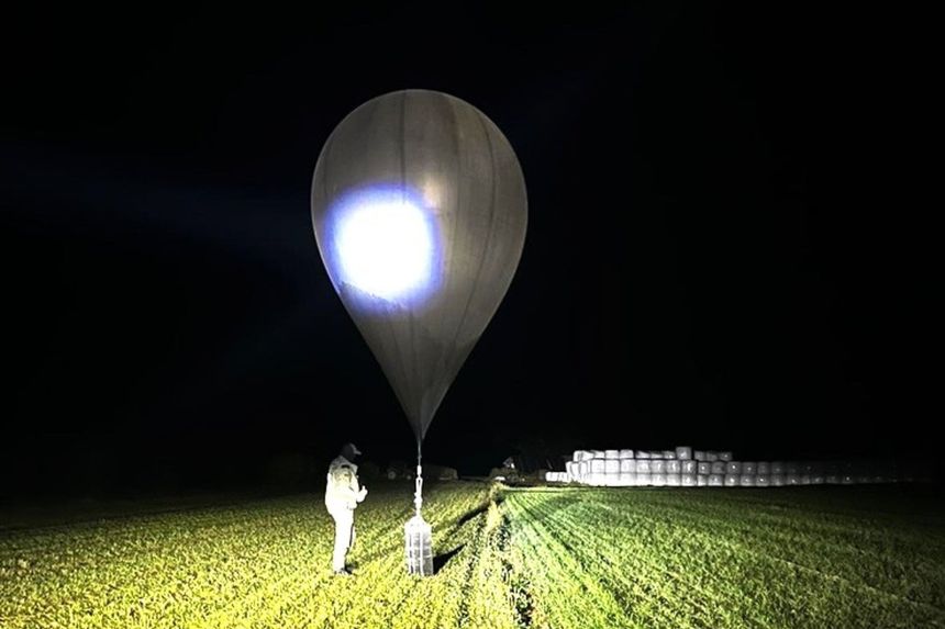 In this undated photo released by the State Border Guard Service, an officer inspects a balloon used to carry cigarettes into Lithuania.