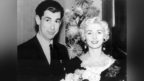 PA Media David Blakely and Ruth Ellis pose for a black and white picture in smart attire