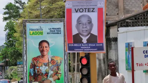 Reuters Campaign billboards for Ahoua Don Mello and Henriette Lagou Adjoua seen on a street in Ivory Coast.