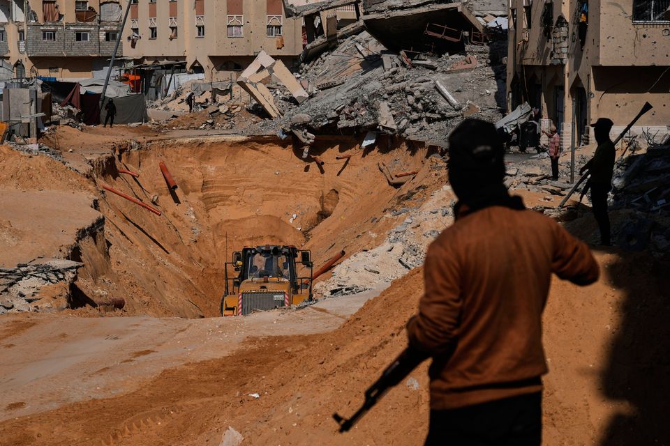 Members of the Hamas militant group search underground for the bodies of Israeli hostages amid destroyed buildings in Khan Younis Photo: AP/Abdel Kareem Hana