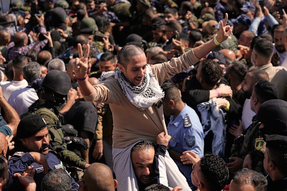 A Palestinian prisoner makes the victory sign after being released.