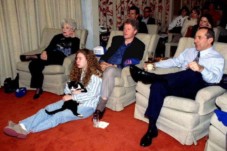 President Bill Clinton watches the Super Bowl with Texas Gov. Ann Richards and New York Gov. Mario Cuomo as Chelsea Clinton sits at her father's feet holding Socks, the family cat, in the East Wing family theater in January 1993.
