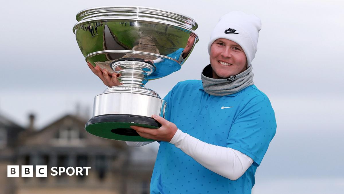 Scotland's Robert MacIntyre poses with the Alfred Dunhill Links trophy on the Swilcan Bridge at St Andrews