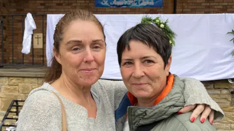 Esther Seymour, a Jewish woman, and Celeste Cavanagh, a Catholic, held hands as they walked to the church to light a candle. Esther’s son has been dating Celeste’s daughter, who is a member of the church congregation. 