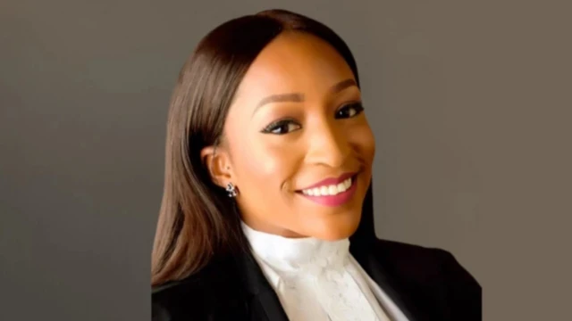 Foto of Sommie on her lawyer dress as she smile to camera
