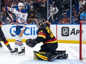 Thatcher Demko stops a tip from Connor McDavid during the first period