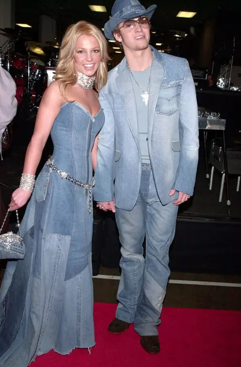 Frank Trapper via Getty Images Britney Spears and Justin Timberlake appear on a red carpet in 2001. They are both wearing full denim outfits in a very famous look that went on to define their relationship together.