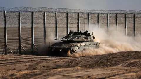 EPA An Israeli tank manoeuvres near the Israeli border with the Gaza Strip, in southern Israel (21 October 2025)