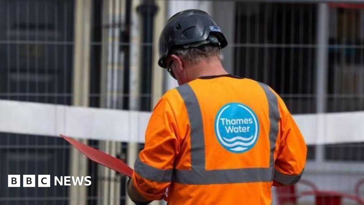 Thames Water worker wearing a bright organe hi-vis jacket and a hard hat