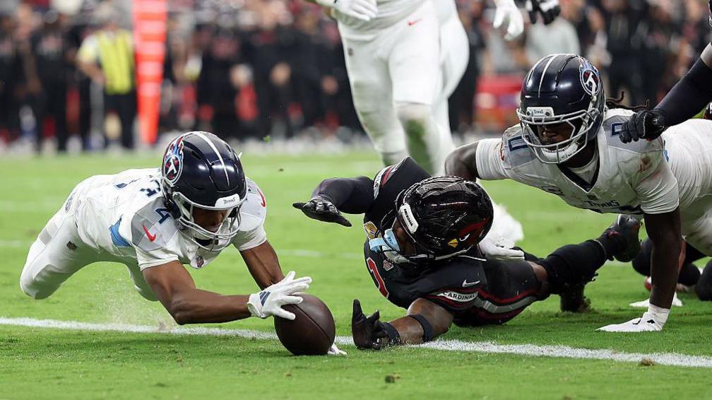 Tyler Lockett dives on the ball to score a touchdown for the Tennessee Titans against the Arizona Cardinals